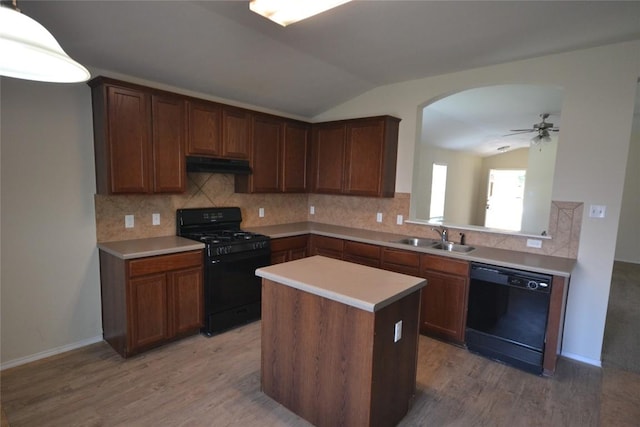 kitchen featuring lofted ceiling, sink, wood-type flooring, black appliances, and backsplash