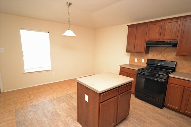 3609 Heron Roost Pass, Pflugerville, TX 78660 - kitchen with black range with gas cooktop, under cabinet range hood, decorative backsplash, brown cabinets, and hanging light fixtures