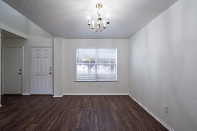 unfurnished dining area with dark wood-type flooring, a notable chandelier, and a textured ceiling