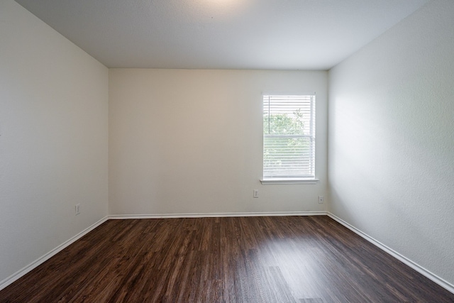 empty room with dark wood-type flooring