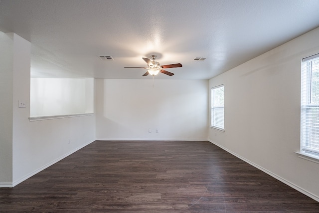 spare room with dark wood-type flooring, ceiling fan, and a textured ceiling