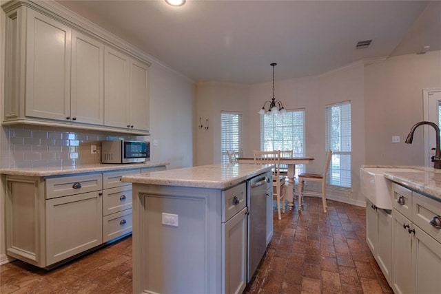 kitchen featuring sink, a center island, pendant lighting, dishwasher, and tasteful backsplash