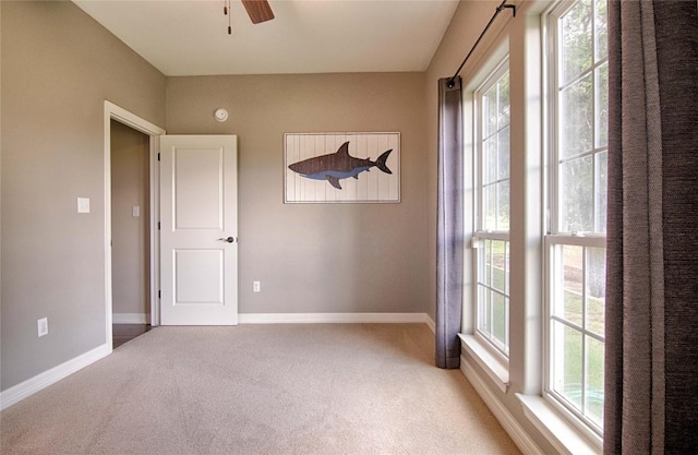 spare room with a wealth of natural light, ceiling fan, and carpet floors