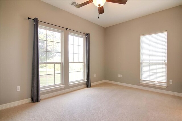 spare room with ceiling fan and light colored carpet