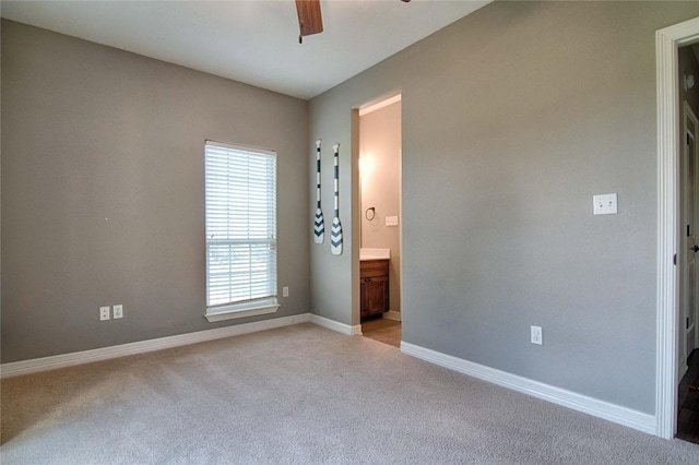 unfurnished bedroom with light carpet, ceiling fan, and connected bathroom