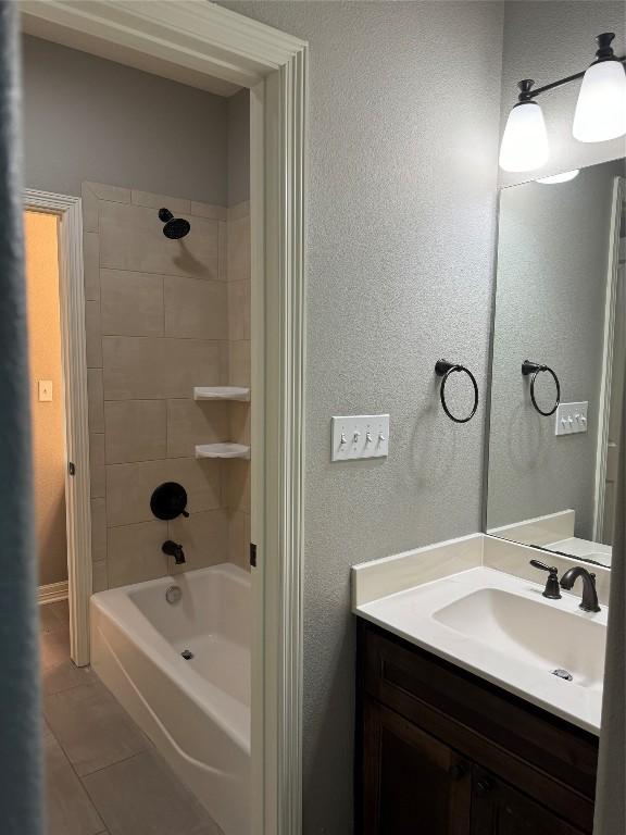 bathroom featuring tiled shower / bath combo, vanity, and tile patterned flooring