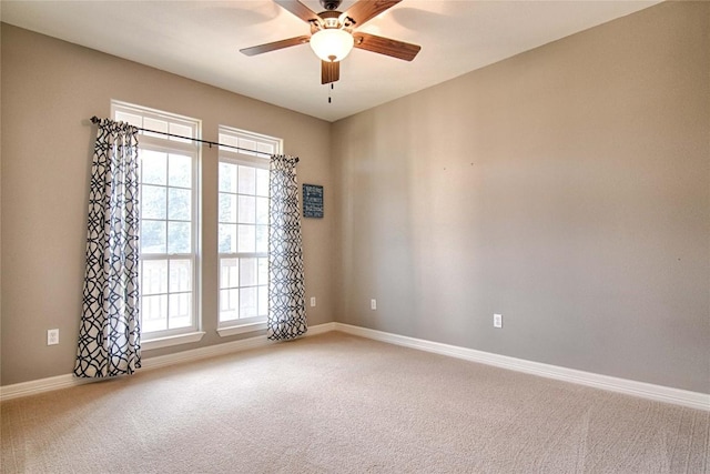 carpeted spare room with ceiling fan