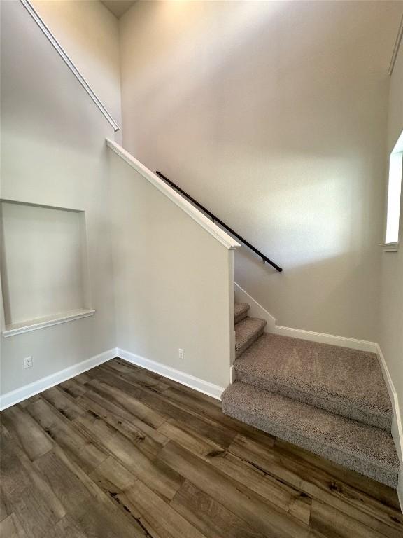 stairs with baseboards and wood finished floors