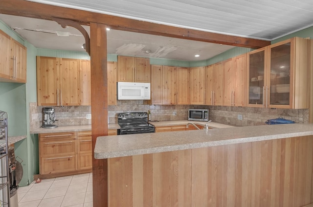 kitchen with light tile patterned floors, tasteful backsplash, black range with electric stovetop, and kitchen peninsula