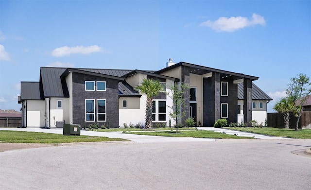 view of front facade with a garage, a front lawn, and cooling unit