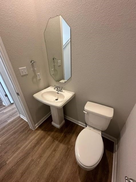 bathroom featuring wood-type flooring and toilet