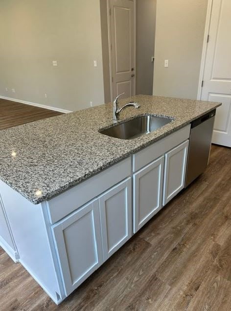 kitchen featuring sink, white cabinetry, light stone countertops, and dark hardwood / wood-style flooring