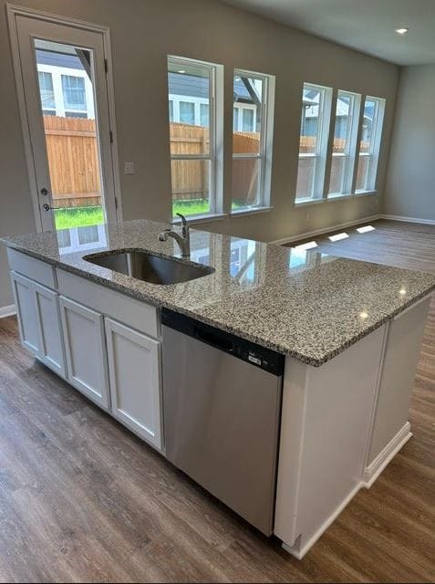 kitchen with sink, stainless steel dishwasher, light stone countertops, white cabinetry, and dark hardwood / wood-style flooring