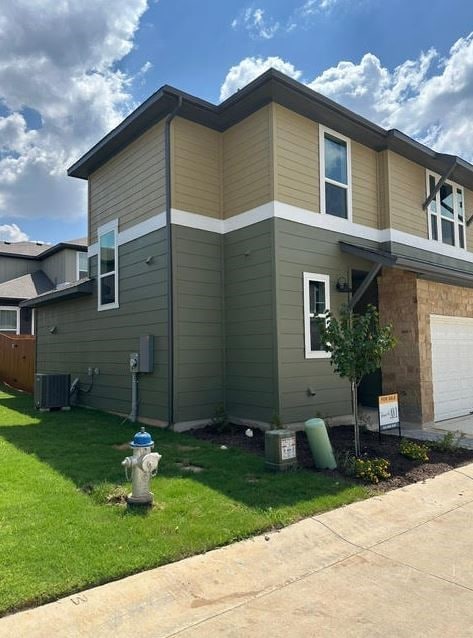 view of property exterior featuring cooling unit, a garage, and a lawn