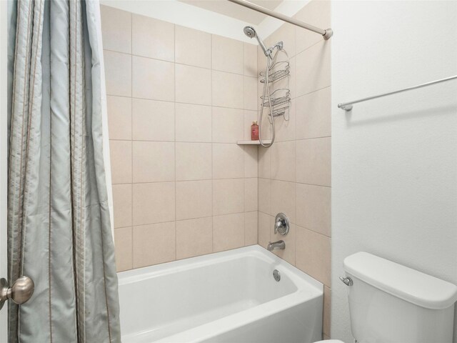 bathroom featuring shower / tub combo and toilet