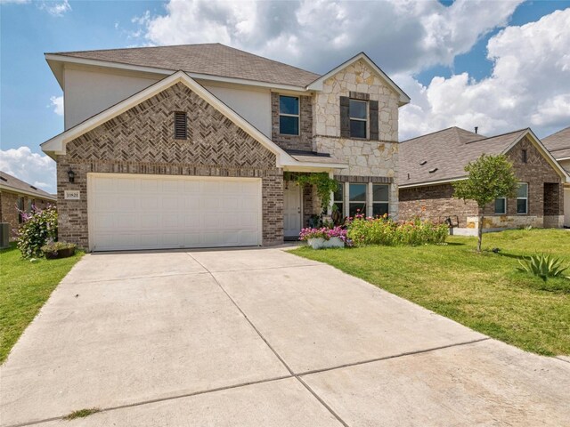 view of front of property featuring a garage, central air condition unit, and a front lawn