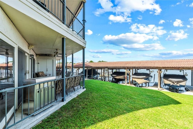 exterior space with boat lift, a balcony, and a lawn