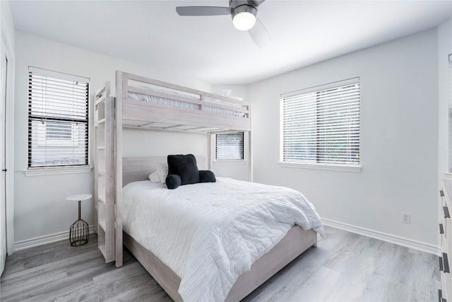 bedroom featuring baseboards, ceiling fan, and light wood finished floors