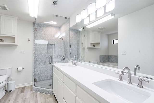 bathroom featuring vanity, hardwood / wood-style floors, toilet, and walk in shower