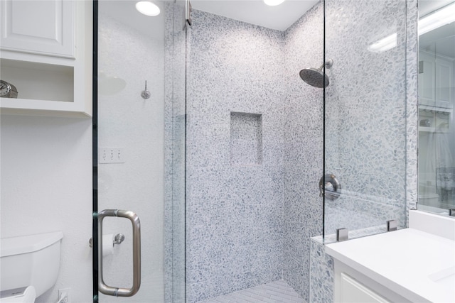 bathroom featuring an enclosed shower, vanity, and toilet