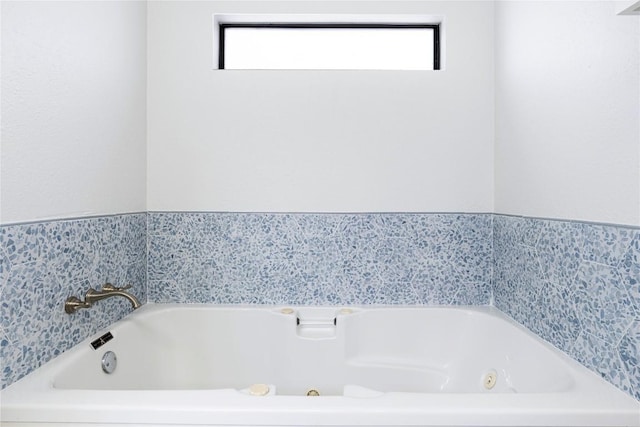 bathroom featuring a healthy amount of sunlight and a whirlpool tub