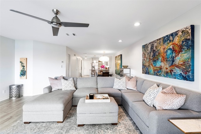 living room with ceiling fan and light wood-type flooring