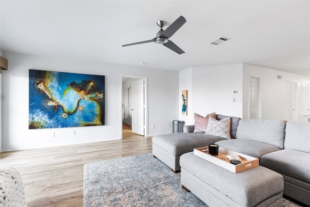 living room featuring wood-type flooring and ceiling fan