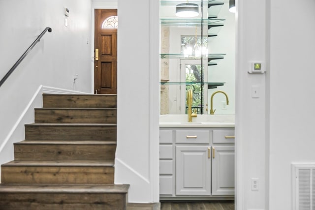 bar with sink, white cabinetry, and dark hardwood / wood-style flooring