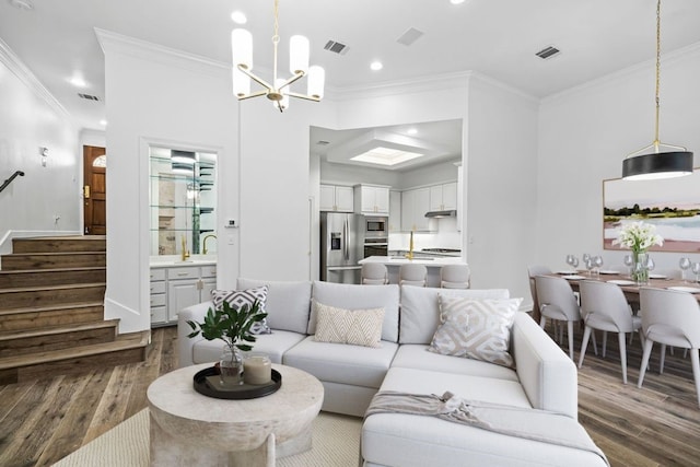 living room featuring crown molding, dark wood-type flooring, and a notable chandelier