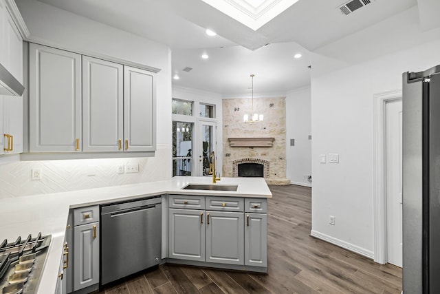 kitchen with appliances with stainless steel finishes, crown molding, tasteful backsplash, and gray cabinets