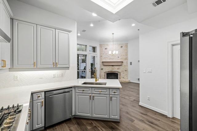 kitchen featuring appliances with stainless steel finishes, dark hardwood / wood-style floors, decorative light fixtures, sink, and gray cabinetry