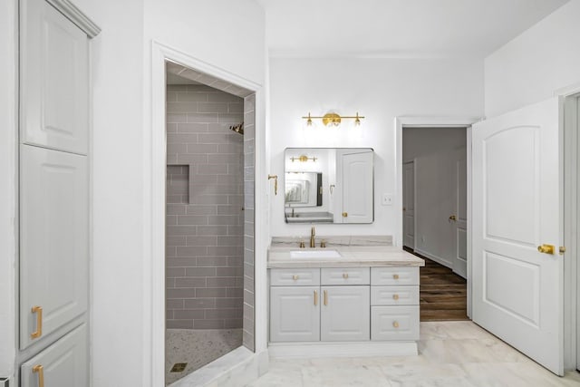 bathroom with vanity and a tile shower