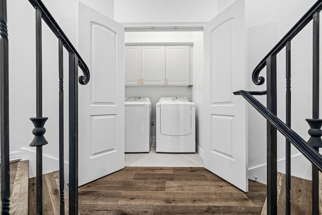 laundry room with dark hardwood / wood-style flooring, cabinets, and washing machine and clothes dryer