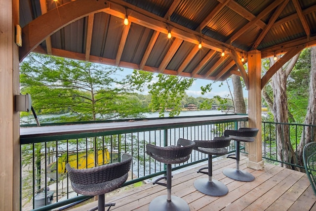 wooden terrace with a water view and a gazebo