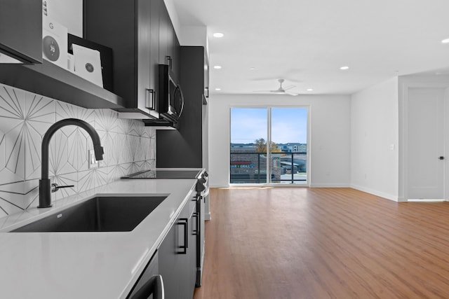 kitchen featuring light hardwood / wood-style floors, sink, ceiling fan, and backsplash