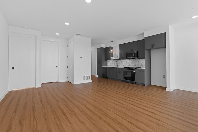 unfurnished living room with sink and light hardwood / wood-style flooring