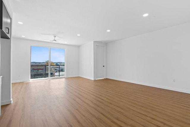 spare room with ceiling fan and light wood-type flooring