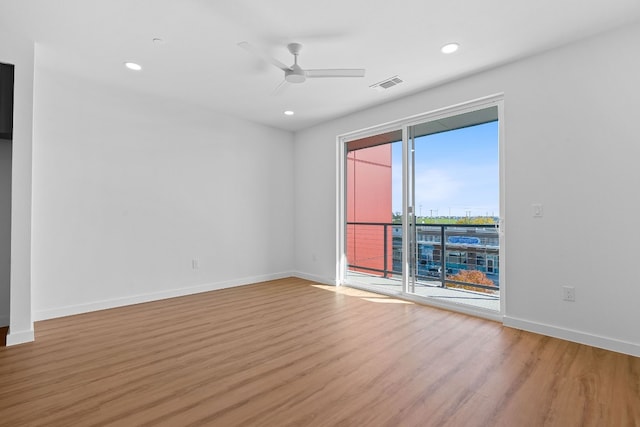 spare room featuring hardwood / wood-style flooring, a healthy amount of sunlight, and ceiling fan