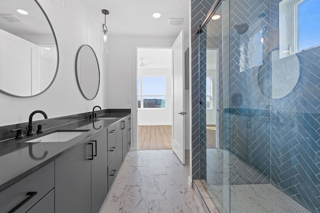 bathroom featuring a shower with shower door, hardwood / wood-style floors, and dual bowl vanity