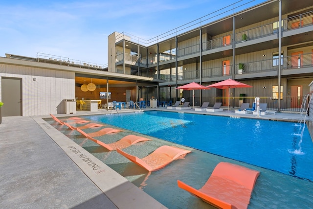 view of swimming pool with pool water feature and a patio