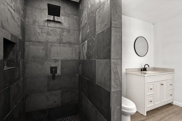 14409 Bois D Arc Ln, Manor, TX 78653 - full bath with tiled shower, toilet, wood finished floors, and vanity