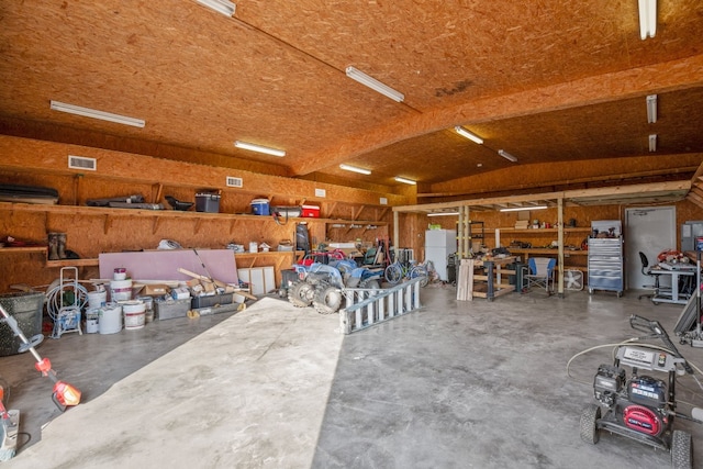 garage with a workshop area and white refrigerator