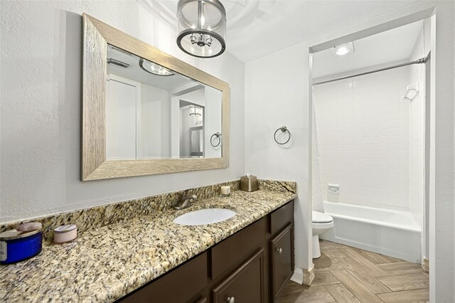 full bathroom featuring tiled shower / bath combo, parquet flooring, toilet, and vanity