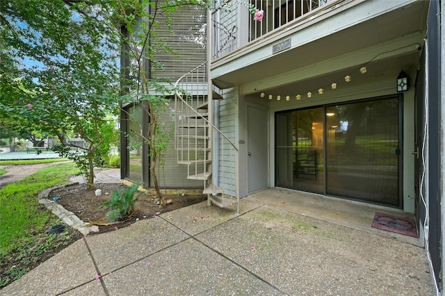 entrance to property featuring a patio and a balcony