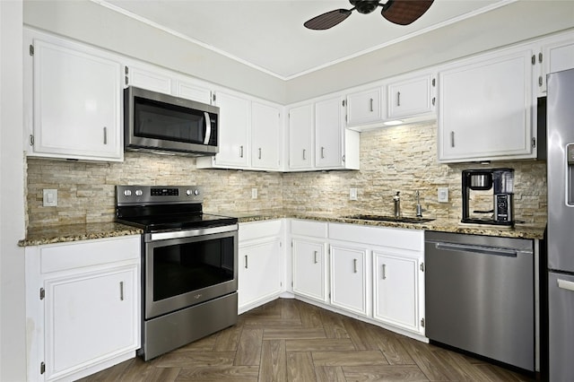 kitchen with dark stone counters, ceiling fan, stainless steel appliances, and dark parquet floors