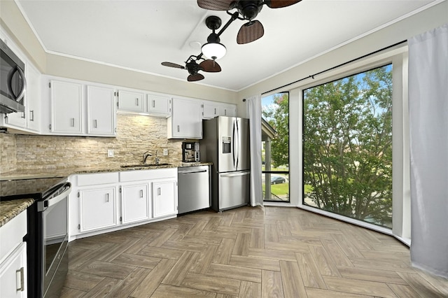 kitchen with parquet floors, ceiling fan, stainless steel appliances, sink, and backsplash