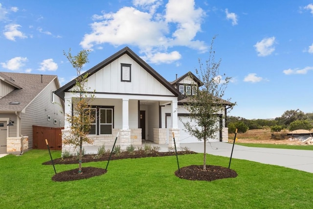 view of front facade with covered porch, a front yard, and a garage