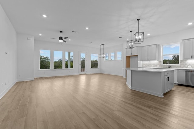 kitchen featuring dishwasher, a center island, plenty of natural light, and light wood-type flooring