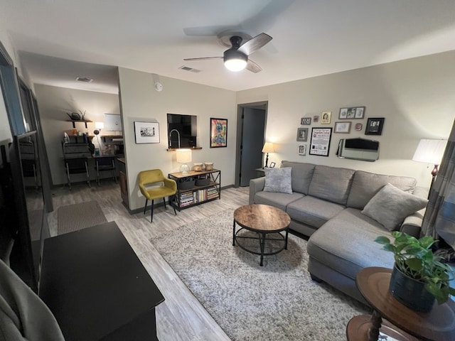 living room with light hardwood / wood-style floors and ceiling fan