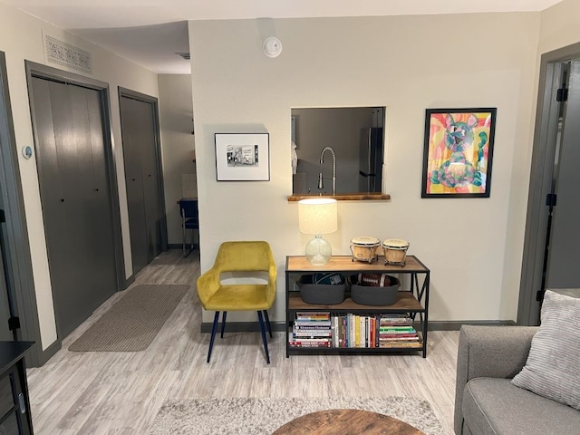 living room with sink and light hardwood / wood-style floors